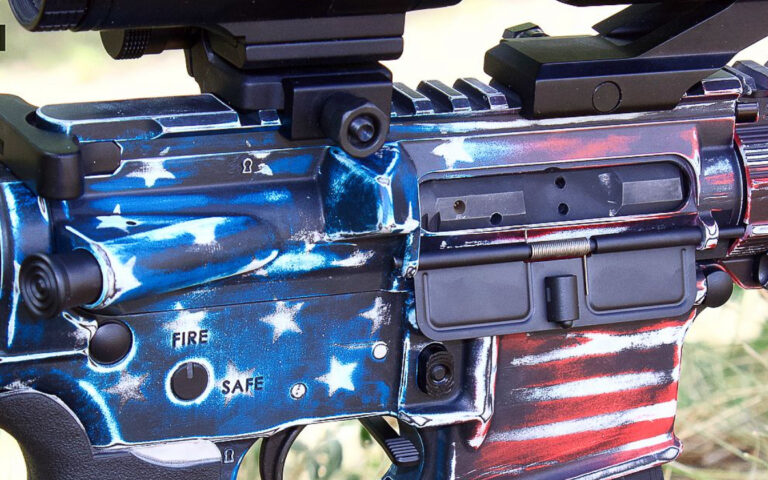 Custom Cerakote AR-15 receiver with distressed American flag design in red, white, and blue.