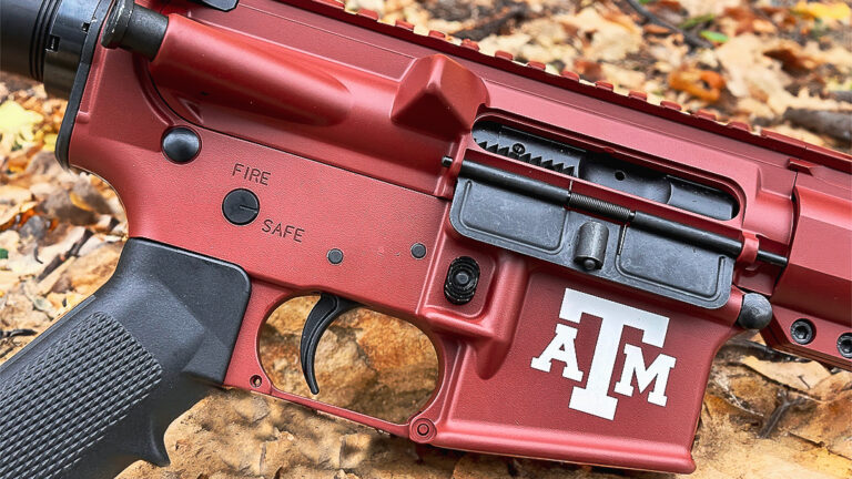 Cerakote-coated AR-15 lower receiver in Texas A&M maroon with white ATM logo, showcasing custom firearm coating finish.
